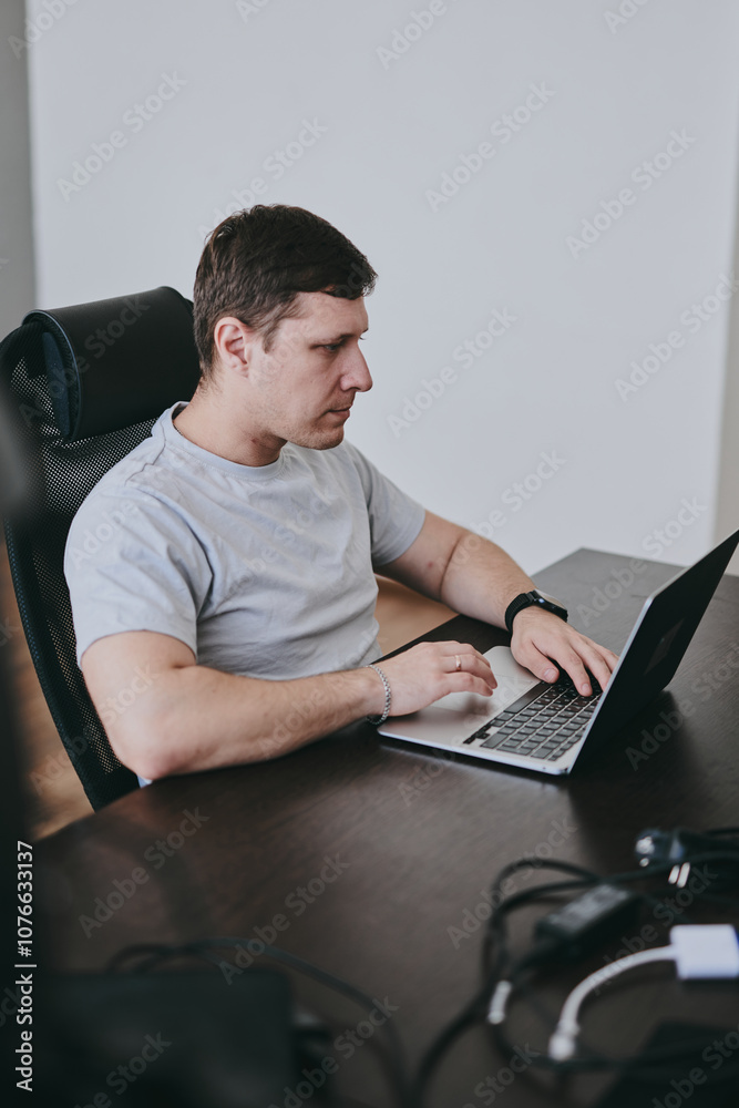 Portrait of young Caucasian male programmer working with laptop in office, software developer, IT technology Portrait of young Caucasian male programmer working with laptop in office, software developer, IT technology