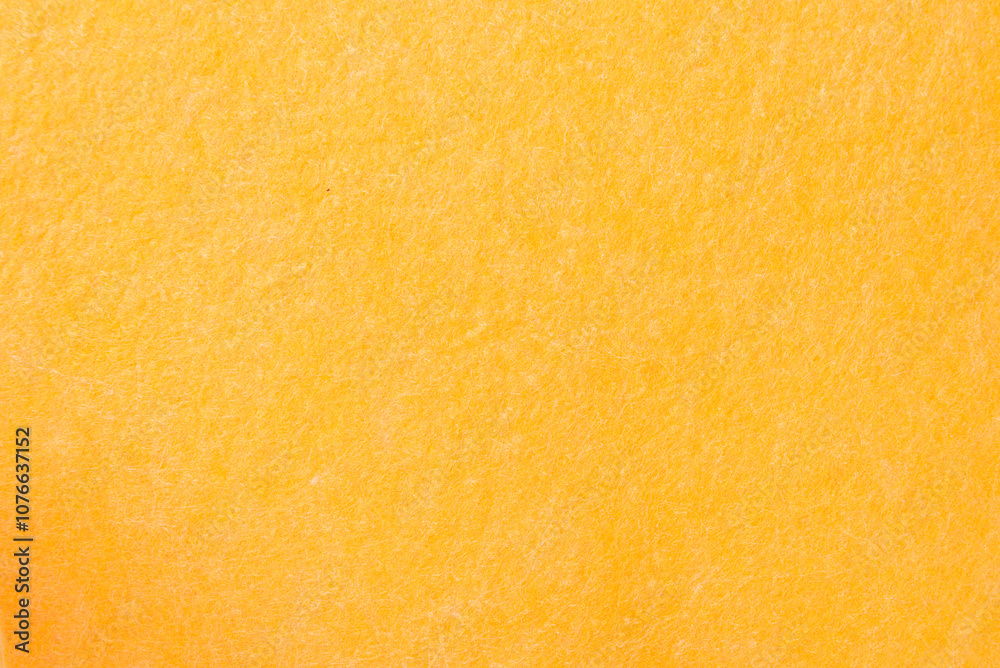 Fototapeta premium Yellow sponge texture background, close-up. Shiny soft sponge, top view