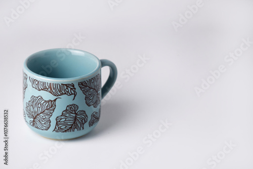 Light blue cup with floral motif on white background photo