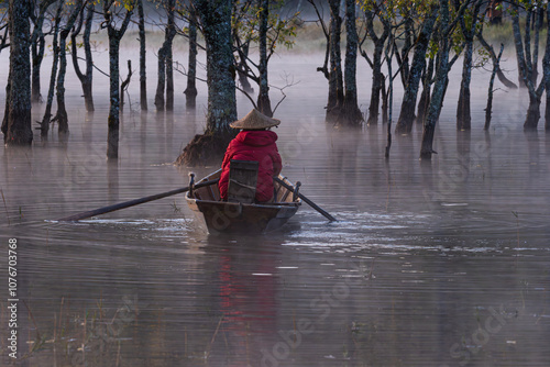 Foggy morning on the stream and the old man on the boat and the dog on the Tia stream, Da Lat. Extremely beautiful scene. Photo taken in Da Lat on January 4, 2004 photo