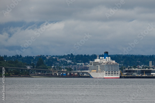 Modern family cruiseship cruise ship liner Luminosa sail away departure from Seattle, Washington State for Alaska summer cruising on grey cloudy day with city skyline