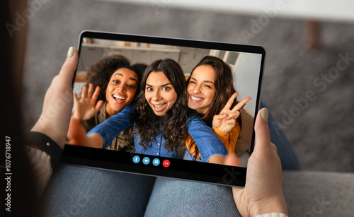 Three friends happily pose for a selfie, enjoying a virtual meeting from their cozy living room. Their smiles convey joy and friendship while they connect online. photo