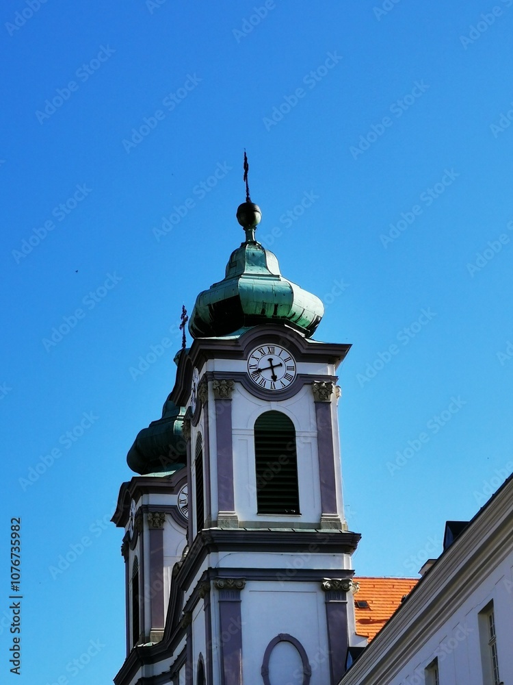 Beautiful clock tower with green domes against a clear blue sky in a historic town Beautiful clock tower with green domes against a clear blue sky in a historic town