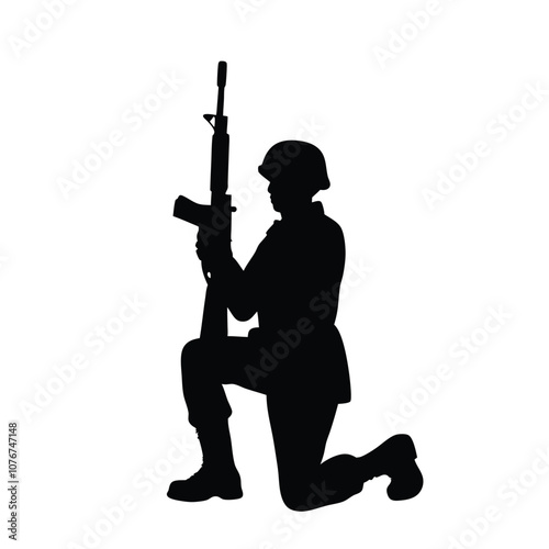A soldier is kneeling down and holding a rifle. He is wearing a helmet. The soldier is in a military uniform