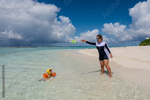 A family is playing on the bikini beach of Mathiveri island of the Maldives photo