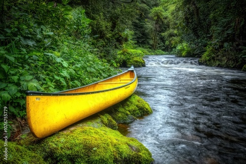 A serene yellow canoe resting by a mossy riverbank surrounded by lush greenery. photo