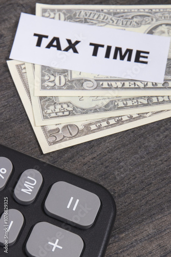 Calculator, inscription tax time and dollar banknotes. Time of calculating, return or tax payment