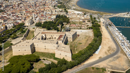 Aerial view of the castle located in Barletta, Puglia, Italy. It was a medieval fortress. In background is the Basilica of Santa Maria Maggiore, cathedral of the city, and the Mediterranean sea.