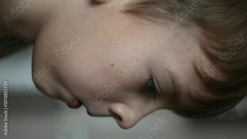 Close-up of a boy with blond hair sitting at the kitchen table and eating a pancake. homemade breakfast.