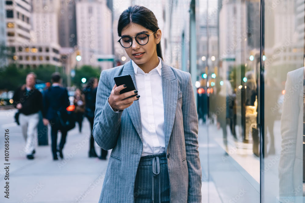 Fototapeta premium Serious business woman in formal wear checking payment operation success via banking application on modern mobile phone connected to 4g wireless for surfing internet, concept of digital marketing