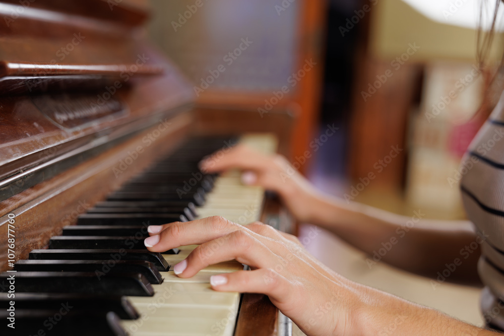 Obraz premium Close-up hands, people sitting at the piano together playing a melody, learning new chords. Young woman takes piano lessons, conservatory, music career.