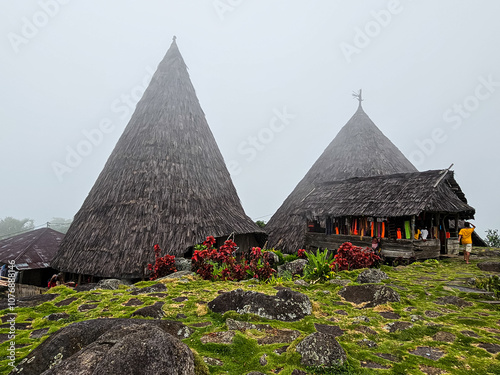 View of Todo Village, a traditional village in Flores, Indonesia with traditional cone-shaped houses, during a foggy day photo