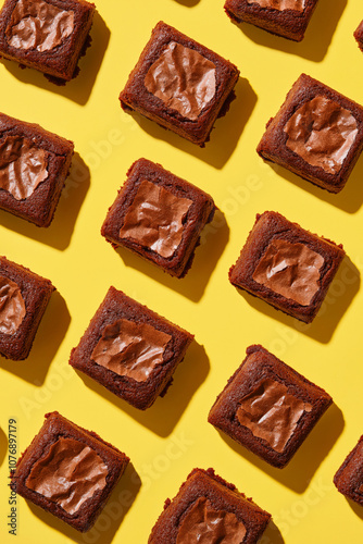 Creative pattern of square-shaped brownies on a yellow background. photo