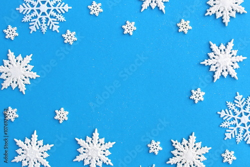  There are many white snowflake figures on a blue background.