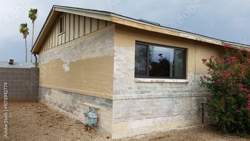 Removing Old Chipped and Flaky Paint from a Single Story Tan Brick House 