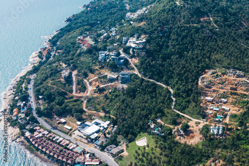 Aerial view of green mountain hills with built-up villas luxury for seasonal rent, housing surrounded by palm trees on an island in Samui, Thailand