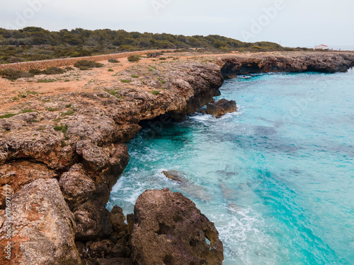 Foto A walk through Sa Cova des Pardals on the coast of Ciutadella; between its turquoise waters and rock formations, Menorca shows us a unique landscape of pure and unspoiled nature
