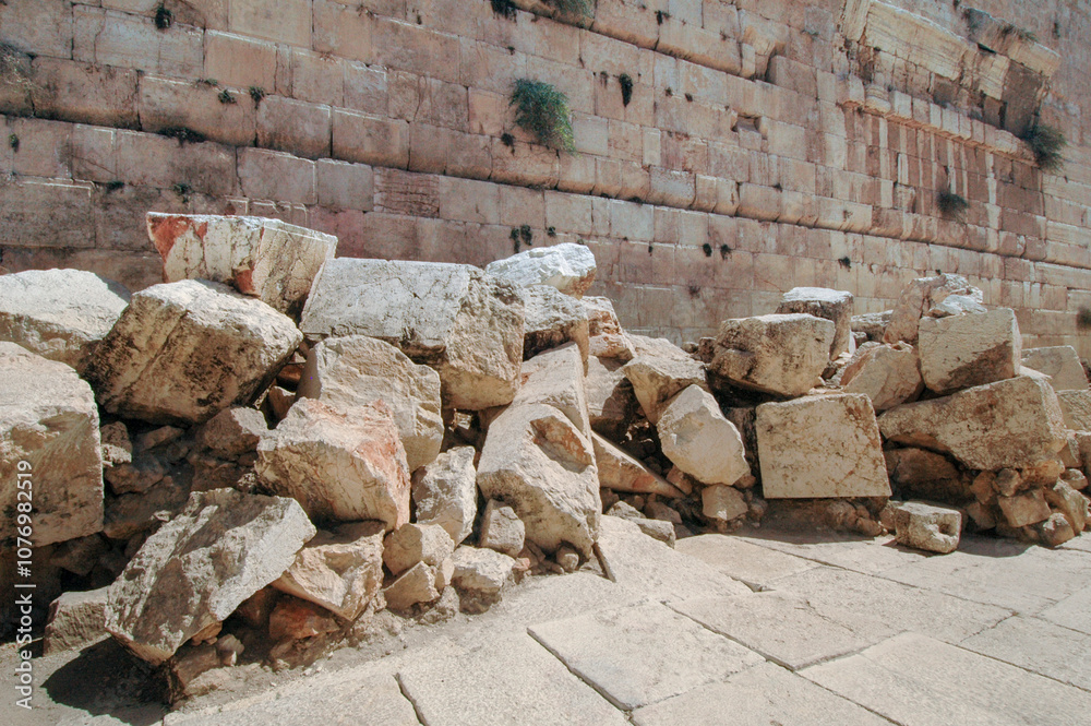 Fototapeta premium Large pile of giant stones at the base of the Western Wall in Jerusalem, beneath Robinson's Arch, said to be ruins of the Second Jewish Temple, destroyed by the Romans in 70 AD.