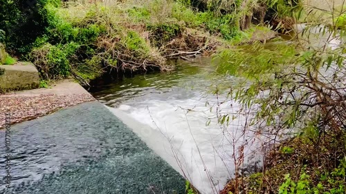 Water running from the river Ouse through a weir into the stream on a cold autumn day in England 