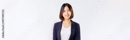 A portrait of an Asian woman wearing a black suit and a white T-shirt against a white background.