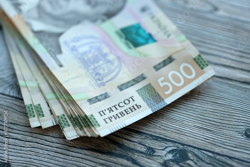 Many five hundred hryvnia money bills lies on wooden background. Ukrainian national currency close up photo