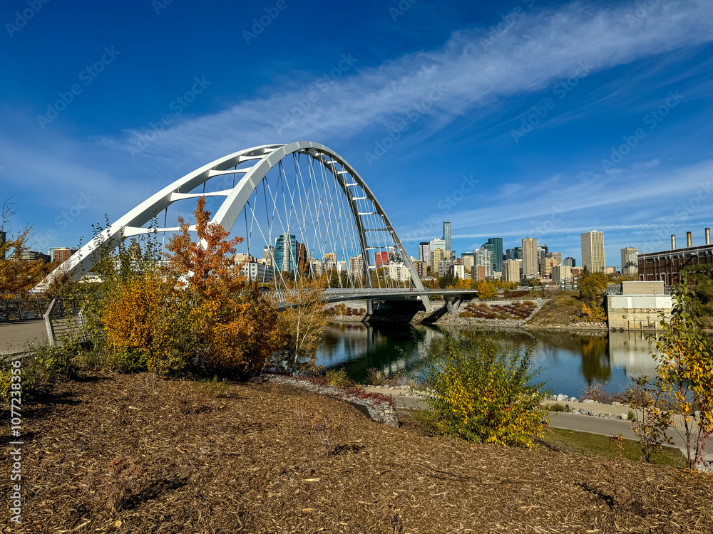 Fototapeta premium Edmonton, Alberta - October 13, 2024: Views of the Edmonton skyline with the Walterdale Bridge over the North Saskatchewan River in the foreground 