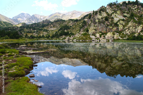 Watched over by the Pic Carlit, the rocky banks of the Bailleul lake are reflected in its clear waters on an August afternoon (Pyrénées Orientales, France)