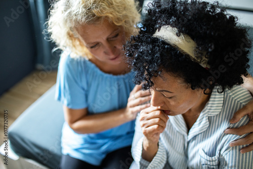 Mature lesbian couple comforting each other during an emotional moment at home photo