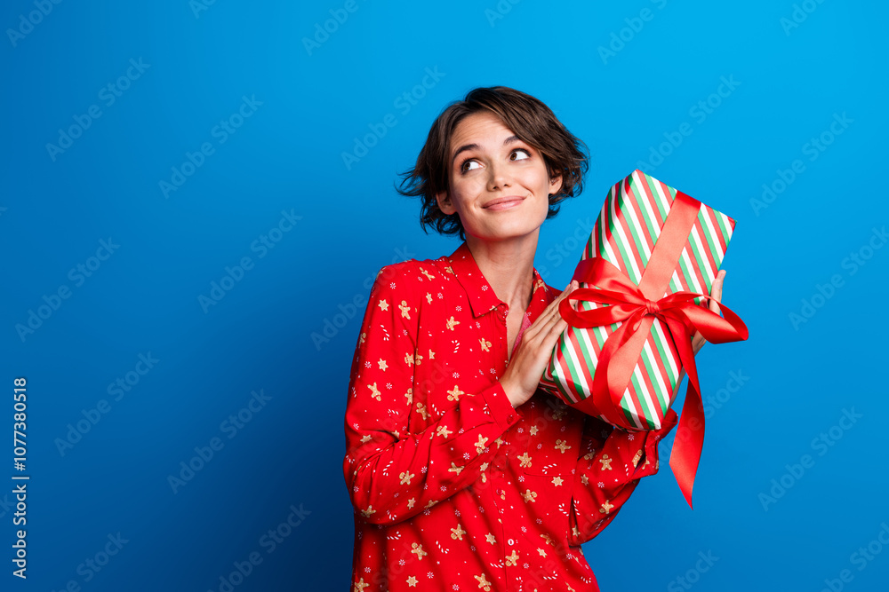 Photo of pretty young woman giftbox look empty space wear red christmas festive shirt isolated on blue color background Photo of pretty young woman giftbox look empty space wear red christmas festive shirt isolated on blue color background