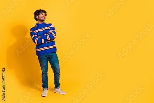 Full size photo of pretty young male crossed hands look empty space wear trendy blue striped outfit isolated on yellow color background