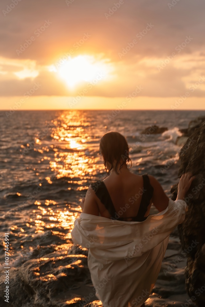 Sunset Woman Ocean Seascape - A woman stands on a rocky shore, watching the sunset over a calm ocean. Sunset Woman Ocean Seascape - A woman stands on a rocky shore, watching the sunset over a calm ocean.