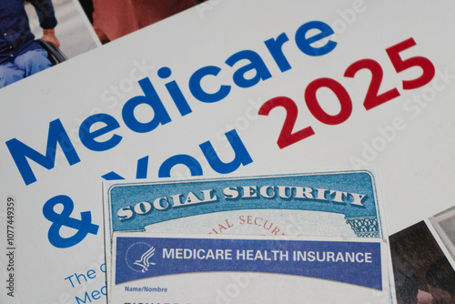 High angle, selective focus view of fake SSN with Medicare cards on 2025 Medicare guide book