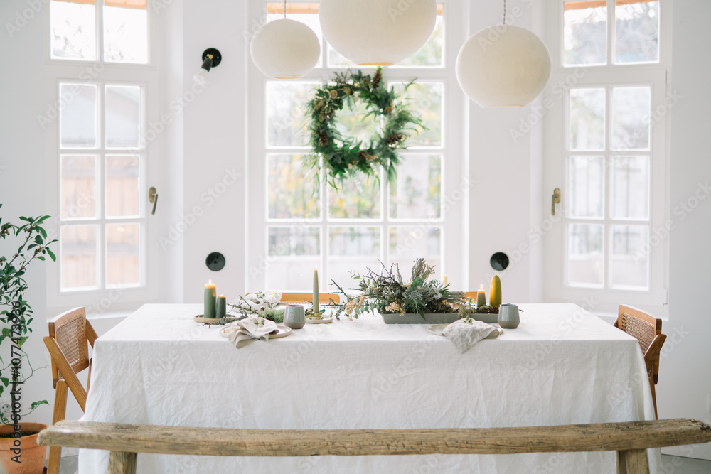 Bright dining room with festive table setting and wreath. Bright dining room with festive table setting and wreath.