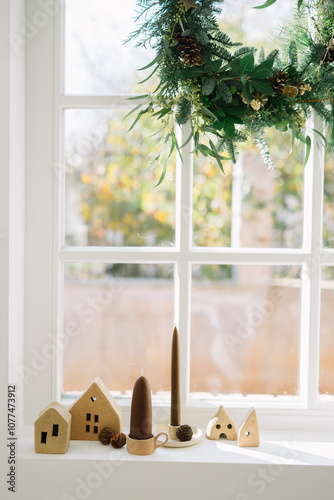 Holiday wreath and village display on bright window photo