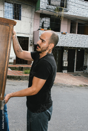 Mocing: Man lifting wooden furniture  photo