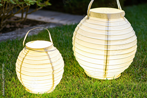 illuminated paper lanterns in evening garden, natural twilig photo