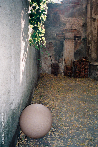 Concrete Ball in Abandoned Courtyard with Wheelbarrows