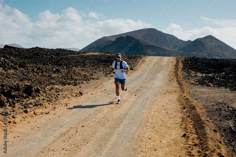 Well-conditioned man hikes through volcanic landscapes of Lanzarote Well-conditioned man hikes through volcanic landscapes of Lanzarote