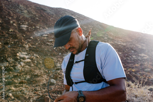 Trail running marathon runner cleans his glasses while taking a break