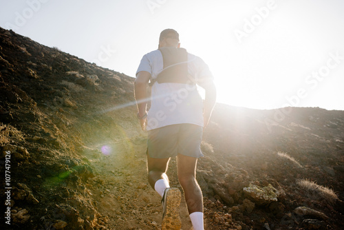 Outdoor trail running enthusiast sprints up a steep volcanic trail