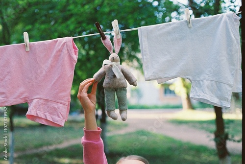 Close-up girl's hand holding washed baby rabbit toy on the street. photo