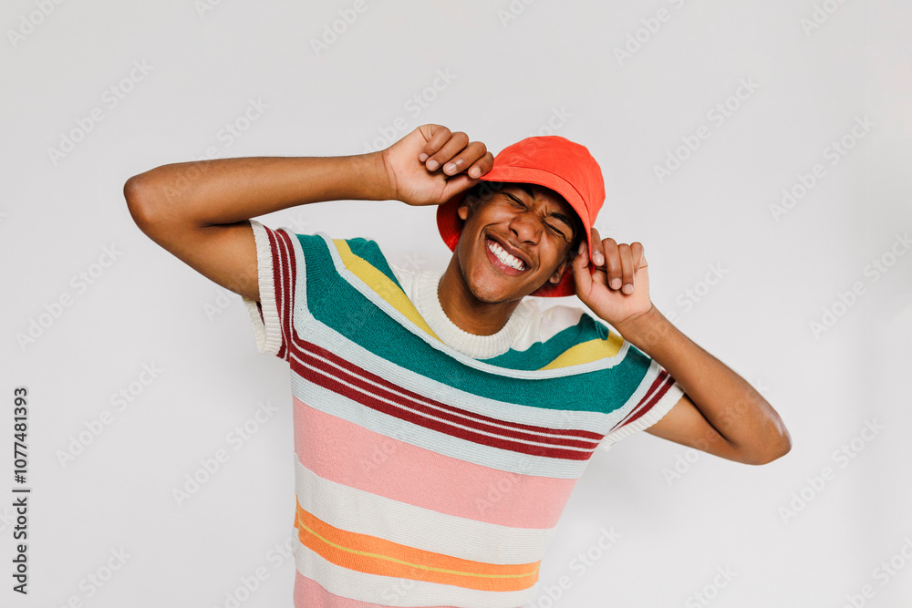 Man wearing colorful clothes and red bucket hat posing in studio Man wearing colorful clothes and red bucket hat posing in studio