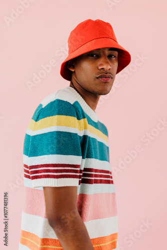 Man wearing red bucket hat and colorful shirt posing on studio photo