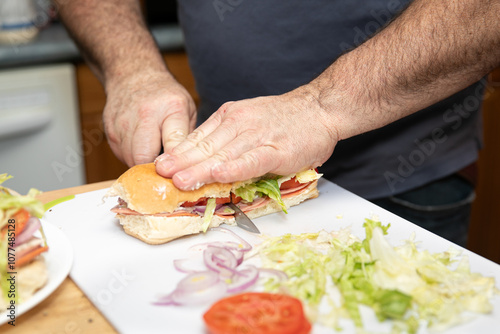 Closeup of hands cutting and making a fresh sub sandwich