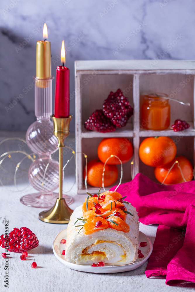 Meringue roll filled with mascarpone, cream and tangerine jam, decorated with tangerines and pomegranate seeds.