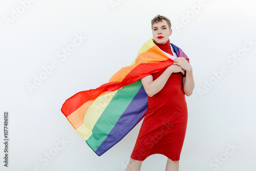 Confident non binary person standing with LGBT flag