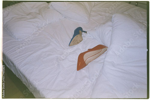 unpaired high heels on an unmade bed, 35mm film