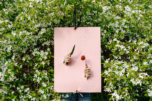 Pink poster with two cutouts showing hands with knife and fork  photo