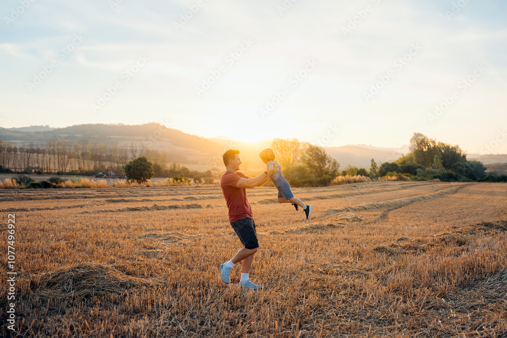 Father Lifting Son in Open Field Father Lifting Son in Open Field