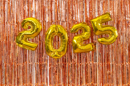 2025 gold balloons with tinsel backdrop

